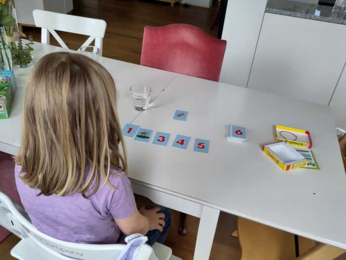 Kinderspiel Fröschis auf dem Spieletisch mit Kind